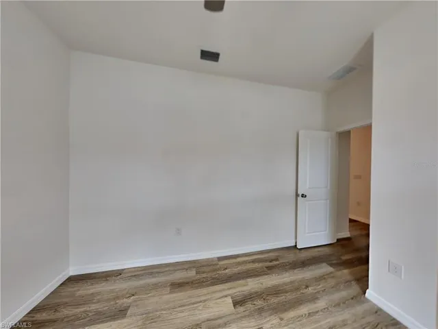 Picture of a previously completed home Unfurnished room with wood finished floors and baseboards