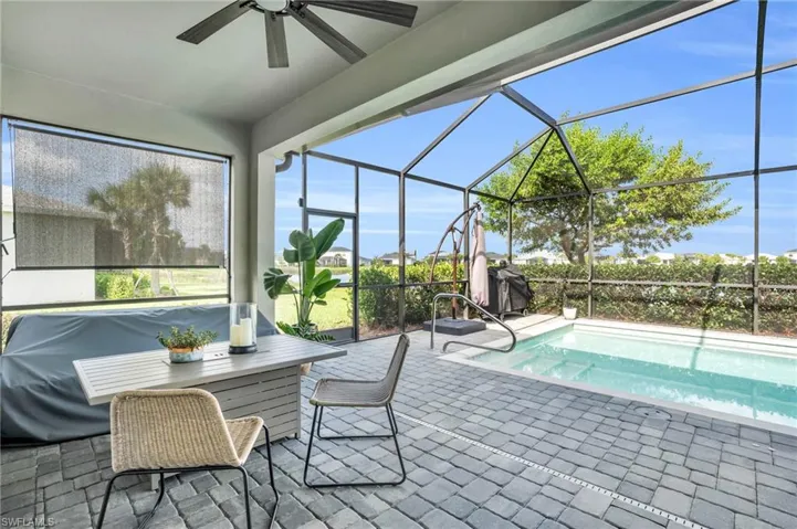 View of swimming pool with a lanai, ceiling fan, and a patio area