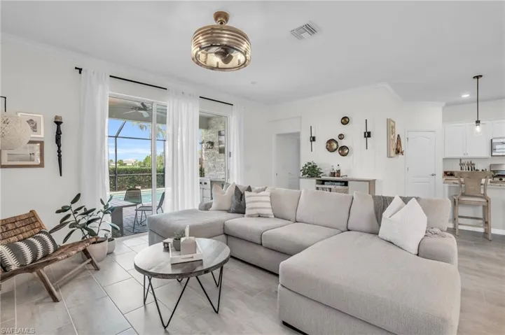 Living room featuring ceiling fan and ornamental molding