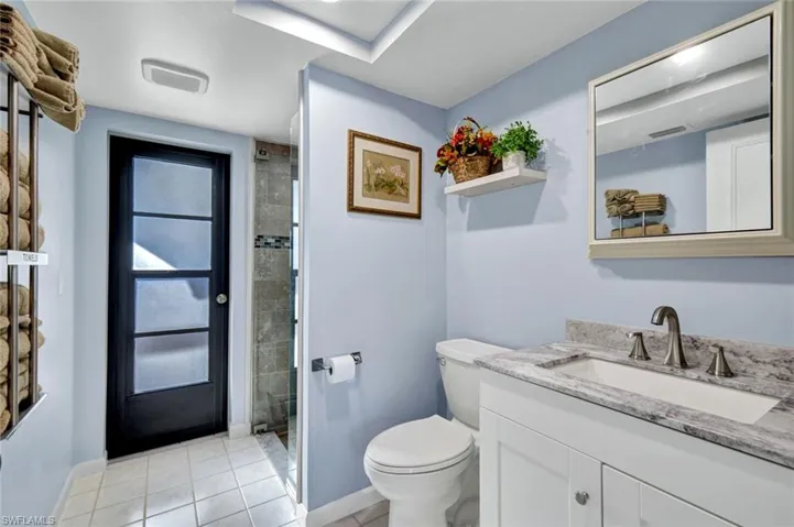 Full bath with vanity, a shower stall, and light tile patterned floors