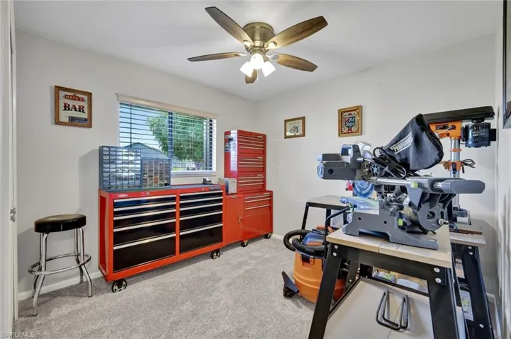 Office space with light carpet and ceiling fan