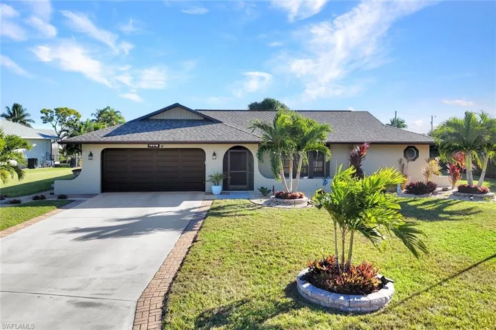 Ranch-style house with concrete driveway, stucco siding, an attached garage, roof with shingles, and a front yard