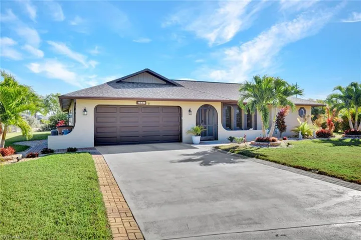 Ranch-style house featuring driveway, a front yard, a shingled roof, stucco siding, and a garage