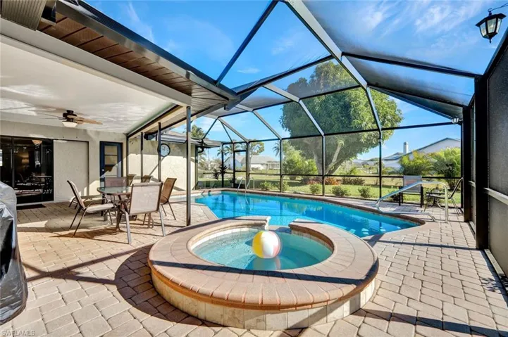View of pool with a patio, a sunroom, a lanai, and a pool with connected hot tub