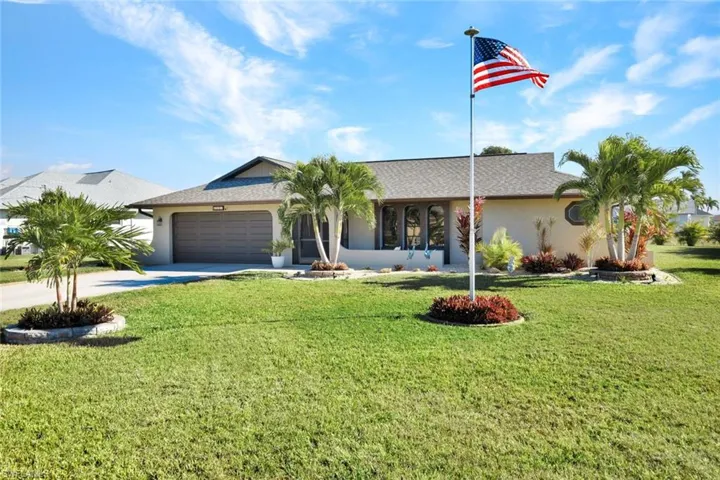 Single story home featuring driveway, stucco siding, an attached garage, and a front yard