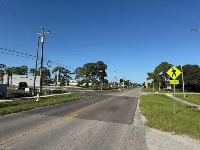 View of asphalt street featuring street lights and traffic signs