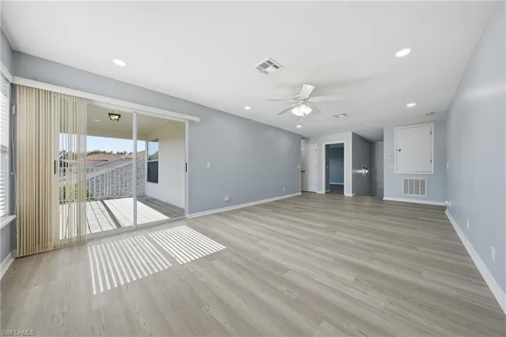 Spacious living area featuring wood-finish flooring, recessed lighting, and a ceiling fan