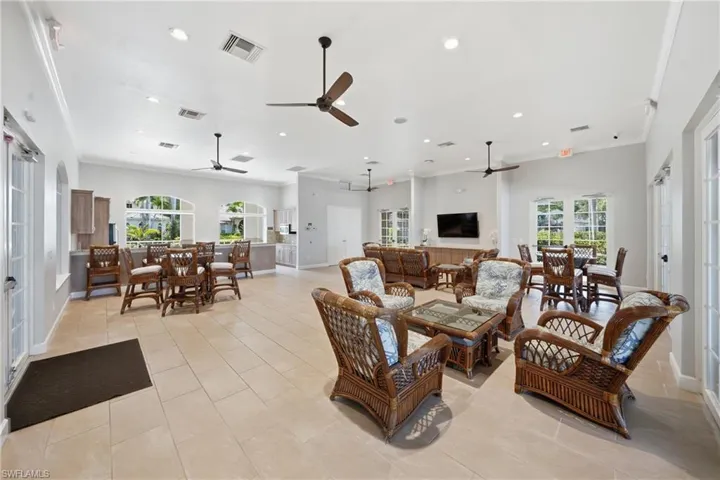 Spacious common area featuring light-toned tile flooring, multiple ceiling fans, and recessed lighting