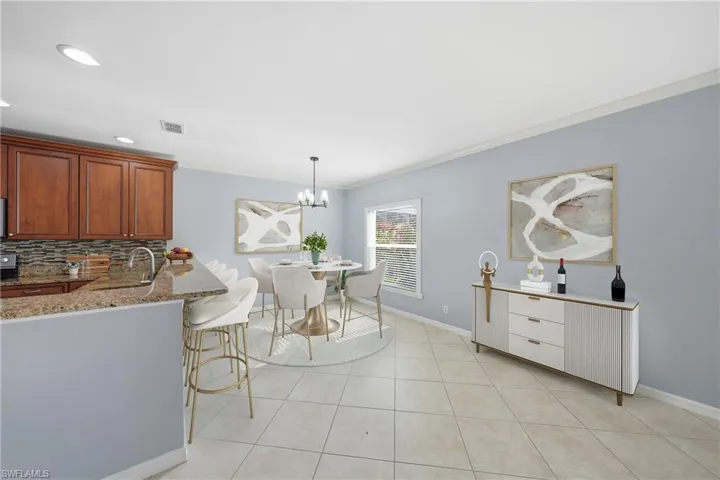 Open-concept living area featuring a kitchen with wood cabinetry, granite countertops, and a tile backsplash