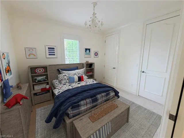 Crown molding, recessed lighting, white paneled doors, and a decorative chandelier
