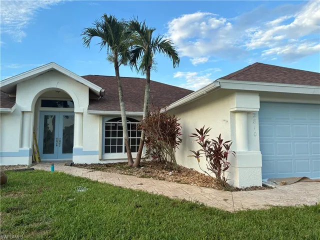 Single-story stucco exterior with an arched entryway
