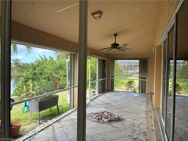 Screened-in porch featuring a ceiling fan, overhead lighting, and sliding glass door access