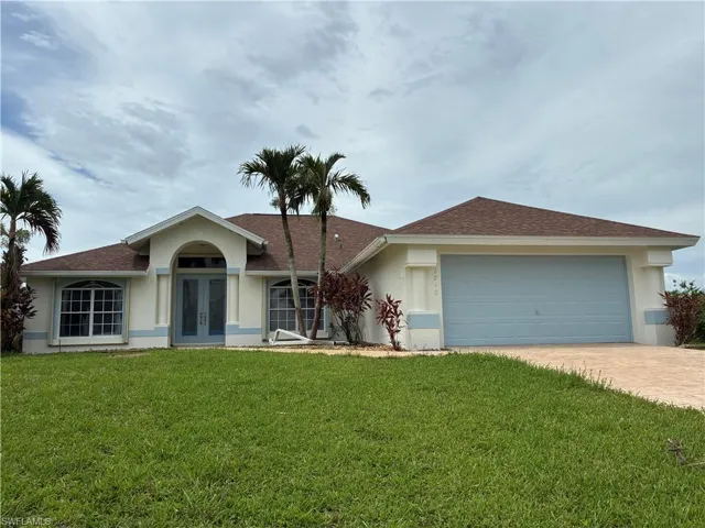 Stucco exterior with arched entry, dual front doors, and a two-car garage