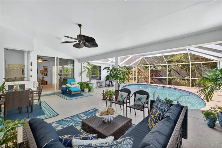 Swimming pool with a patio, a lanai, a sunroom, and an outdoor living / dining area