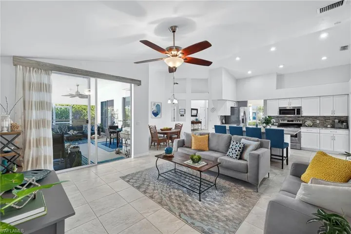 Living room featuring lofted ceiling, ceiling fan, and recessed lighting