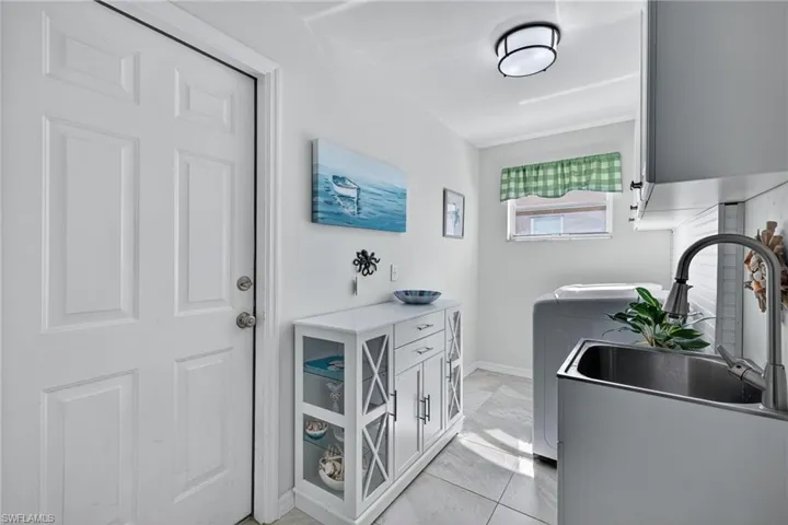 Laundry room featuring cabinet space and baseboards