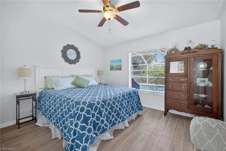 Bedroom with wood tiled floors, lofted ceiling, and a ceiling fan