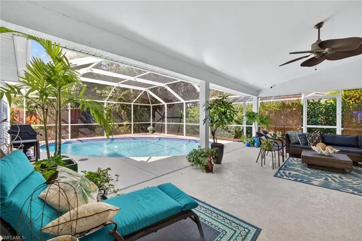 Outdoor pool with outdoor furniture, a sunroom, area for grilling, a patio area, and glass enclosure