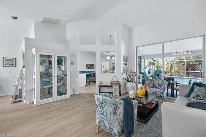 Living area with vaulted ceiling, wood finish floors, and a ceiling fan