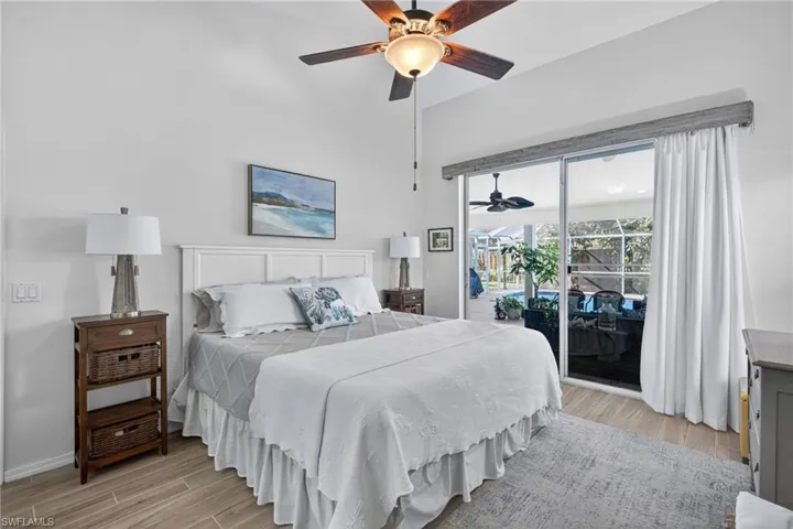 Bedroom featuring wood finish floors, access to outside, and ceiling fan