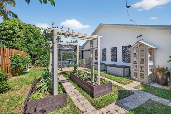 Fenced backyard with a garden, a pergola, and a patio