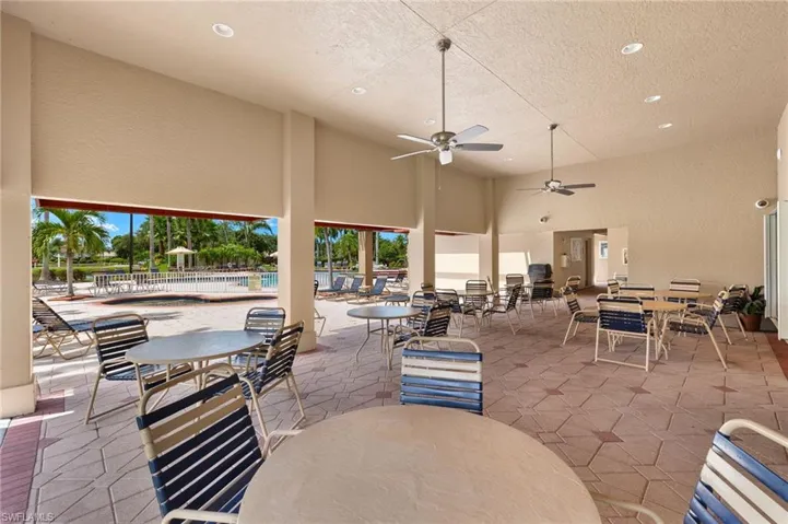 View of patio with outdoor dining area, a ceiling fan, and a community pool