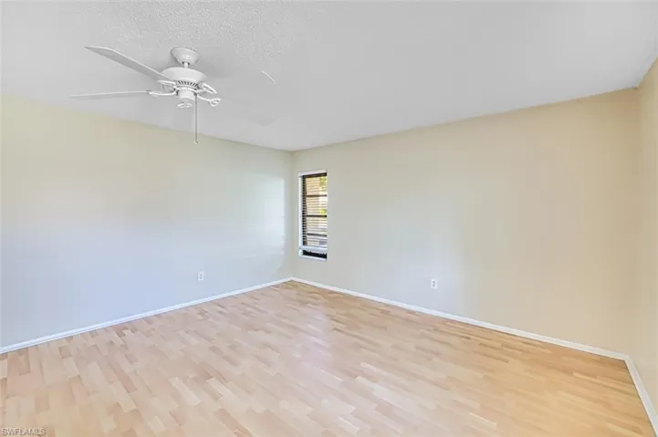Unfurnished room featuring light wood finished floors, a ceiling fan, and a textured ceiling