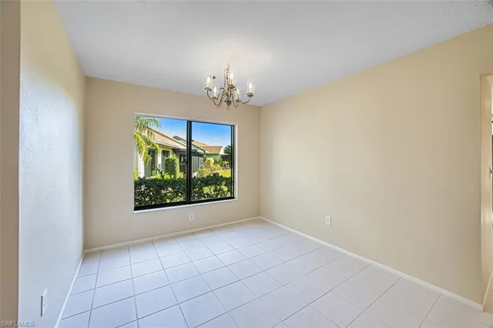 Empty room featuring a chandelier and light tile patterned floors