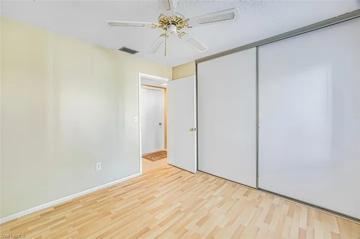 Unfurnished bedroom with wood finished floors, a ceiling fan, a textured ceiling, and a closet