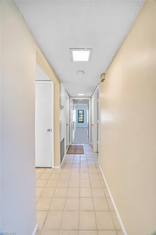 Hall with light tile patterned floors and a textured ceiling