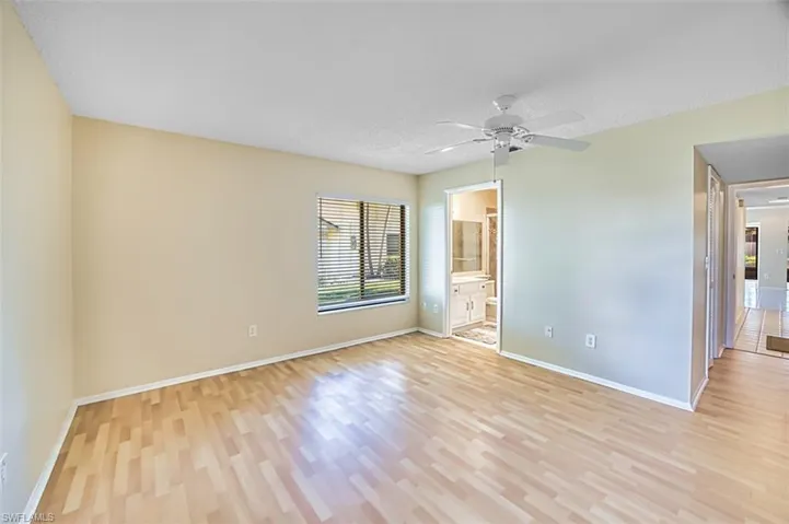 Unfurnished bedroom with a ceiling fan, a textured ceiling, light wood finished floors, and ensuite bath