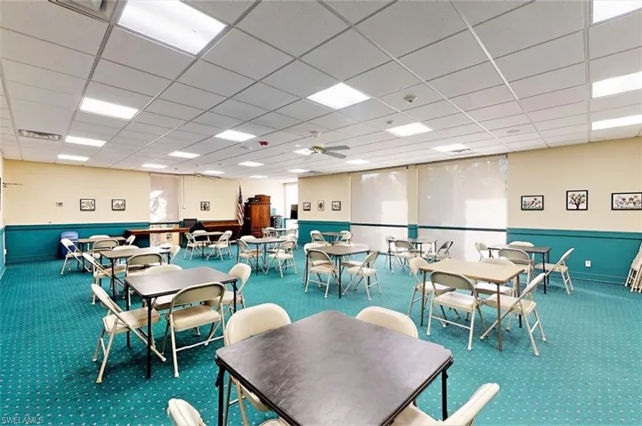 Carpeted dining room featuring a ceiling fan and a drop ceiling