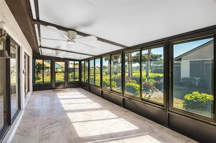 Unfurnished sunroom featuring a ceiling fan