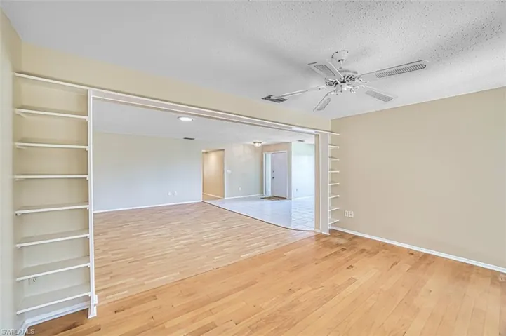 Spare room featuring light wood-style flooring, a textured ceiling, and a ceiling fan