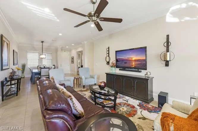 Living room featuring ornamental molding, recessed lighting, light tile patterned flooring, and a ceiling fan