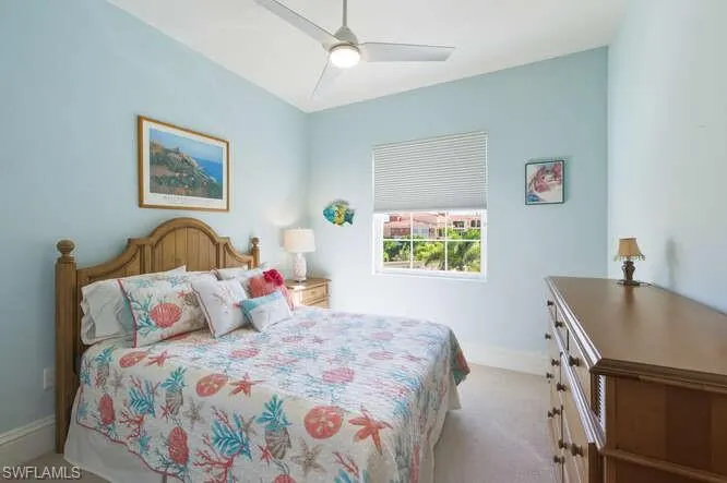 Bedroom with a ceiling fan and light colored carpet