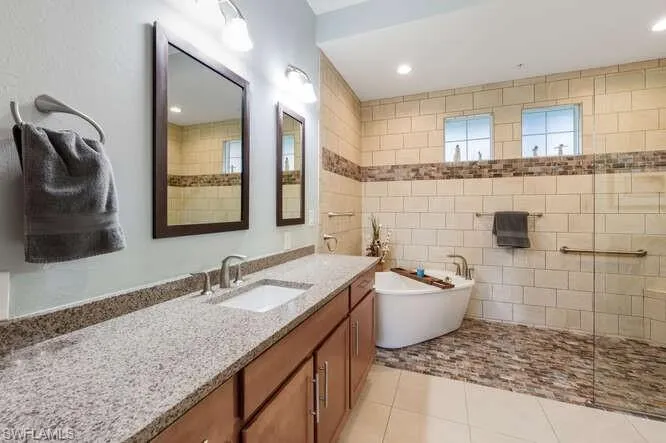 Full bathroom featuring vanity, a soaking tub, light tile patterned floors, recessed lighting, and walk in shower