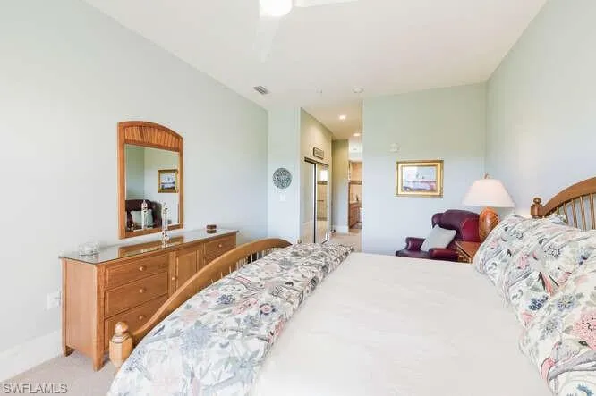 Bedroom with a closet, a ceiling fan, and light carpet