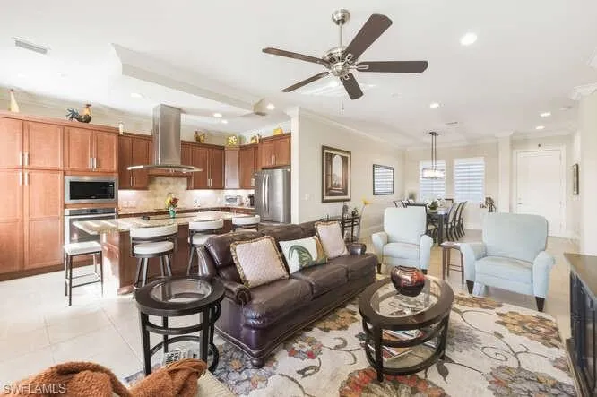 Living room featuring ornamental molding, recessed lighting, light tile patterned flooring, and ceiling fan