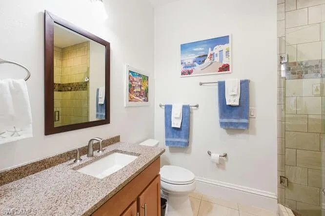Full bathroom with vanity, a stall shower, and light tile patterned floors