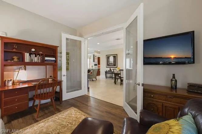 Office space with french doors, wood finished floors, and built in desk