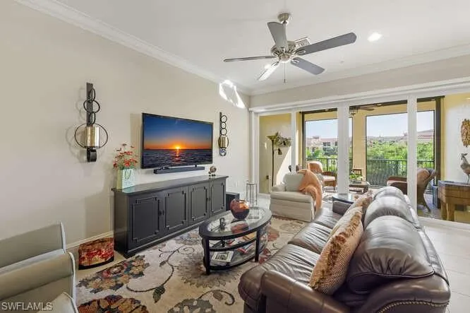 Living room with ornamental molding and ceiling fan
