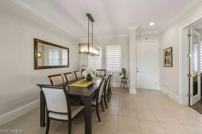 Dining area with light tile patterned floors, ornamental molding, and recessed lighting