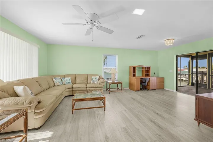 Living area featuring visible vents, a healthy amount of sunlight, a ceiling fan, and wood finished floors