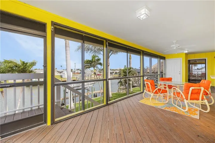 Sunroom featuring ceiling fan and a water view