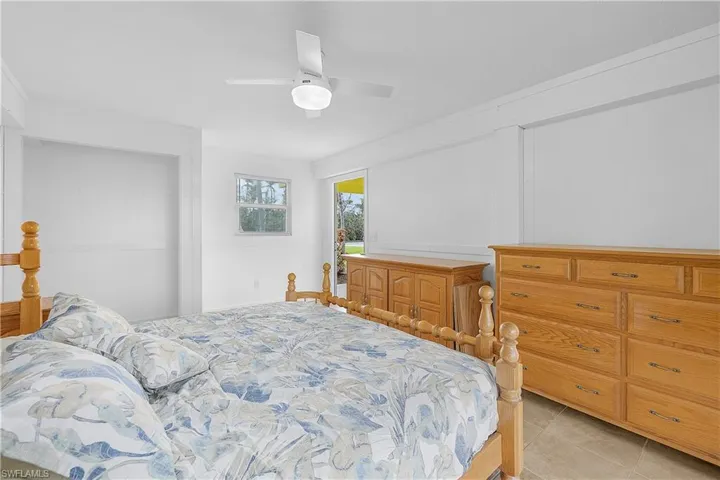 Bedroom with light tile patterned flooring and ceiling fan