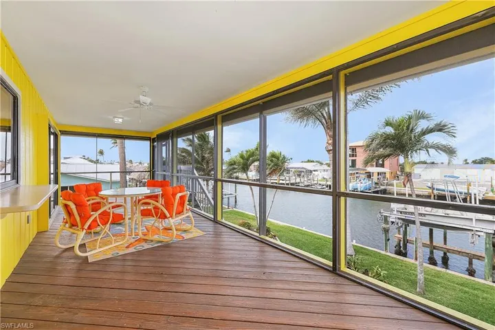 Sunroom with a water view and ceiling fan