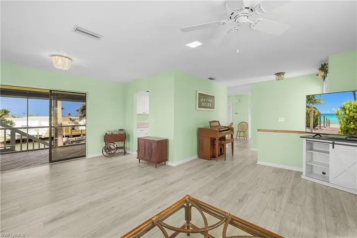 Living room with a ceiling fan, light wood-style floors, visible vents, and baseboards
