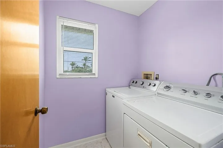 Laundry room with laundry area, baseboards, and washing machine and clothes dryer