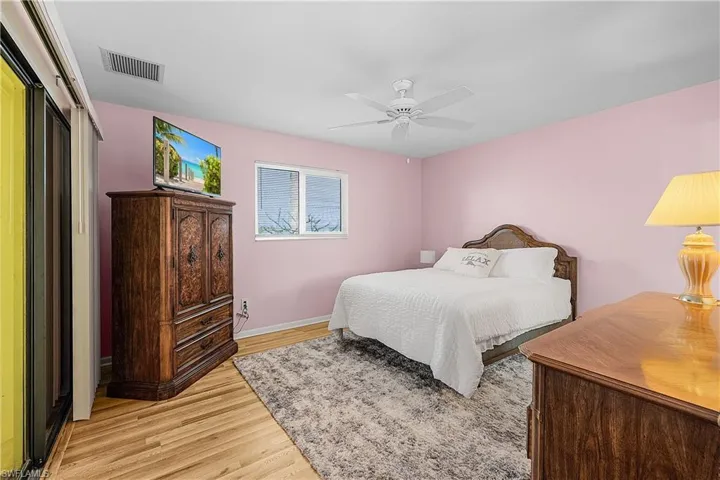 Bedroom featuring a ceiling fan, baseboards, visible vents, and light wood finished floors